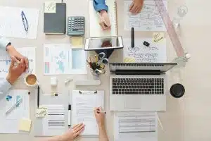 Estratégia B2B: Visão superior de mesa com planners, esquemas e equipamentos.