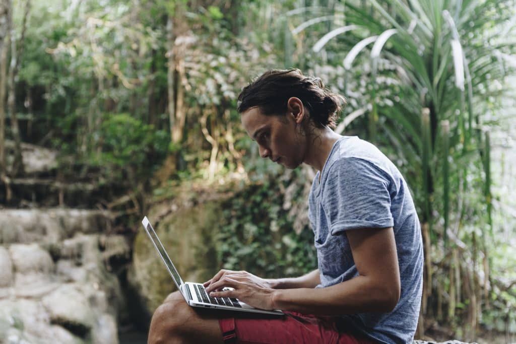 Google EEAT: homem branco usando notebook na natureza.