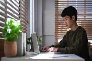 Google imagens e SEO. Homem asiático usando notebook.