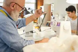 SEO para produtos. Homem mexendo em máquina de costura.
