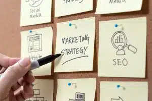 o que é seo no marketing. Pessoa escrevendo em papel adesivo.